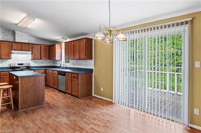 103 Forest Dr, King, NC 27021 - kitchen with stainless steel appliances, dark countertops, vaulted ceiling, brown cabinetry, and light wood-style floors