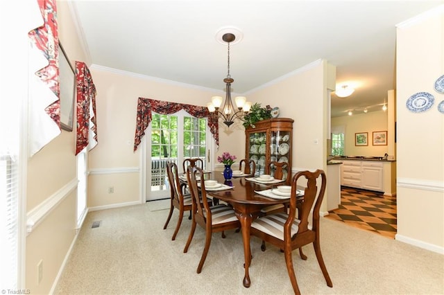 dining room featuring baseboards, ornamental molding, visible vents, and a notable chandelier