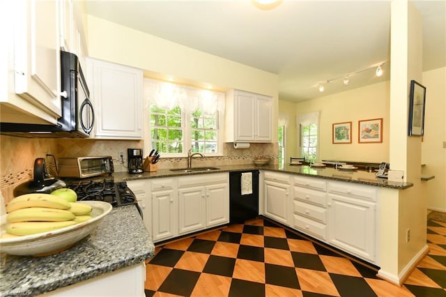 kitchen featuring a sink, dark stone countertops, white cabinetry, decorative backsplash, and black appliances