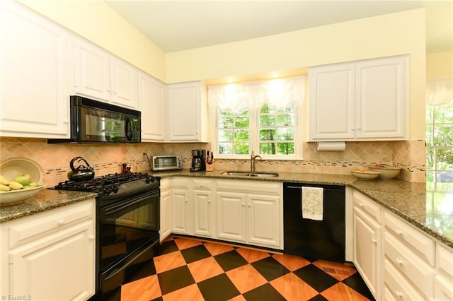 kitchen featuring a sink, decorative backsplash, black appliances, and a wealth of natural light