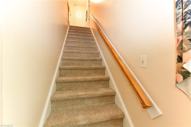 staircase with baseboards and carpet