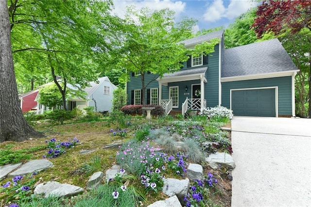 view of front of property with a garage, a porch, driveway, and roof with shingles