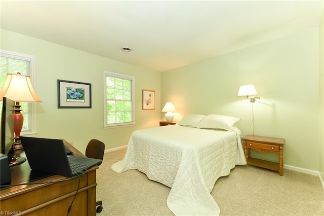 bedroom with baseboards, visible vents, and light colored carpet