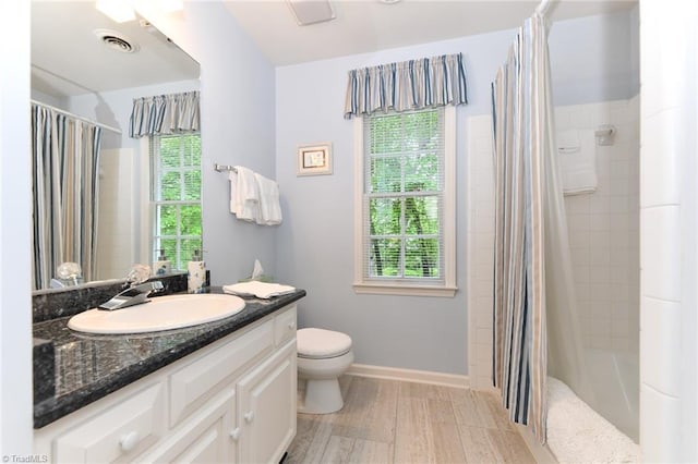 full bathroom with vanity, toilet, shower / bath combination with curtain, wood finished floors, and visible vents