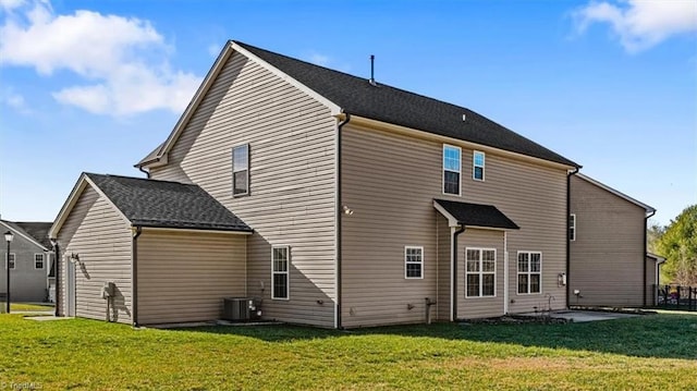 back of house with cooling unit and a lawn