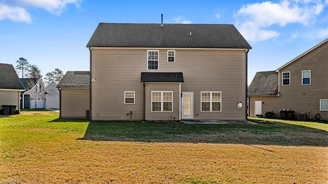 back of property featuring central AC unit and a lawn