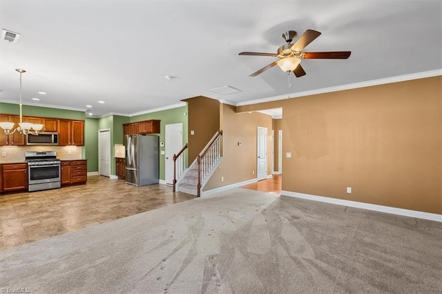 kitchen featuring light colored carpet, decorative light fixtures, appliances with stainless steel finishes, crown molding, and ceiling fan with notable chandelier