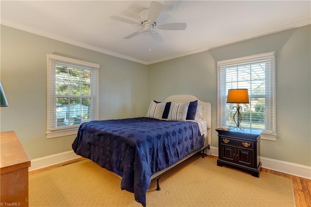 bedroom featuring multiple windows, crown molding, ceiling fan, and light hardwood / wood-style floors