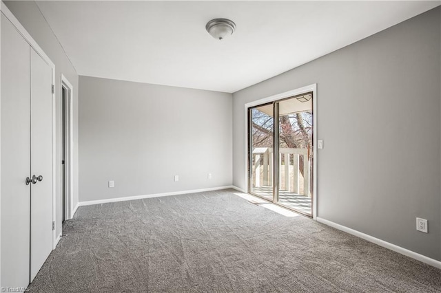 unfurnished room featuring carpet floors and baseboards