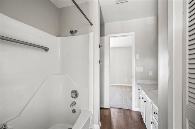 bathroom with visible vents, bathing tub / shower combination, vanity, and wood finished floors