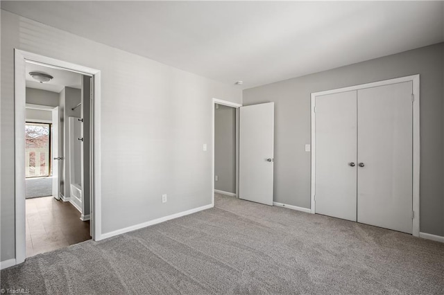 unfurnished bedroom with a closet, carpet flooring, and baseboards