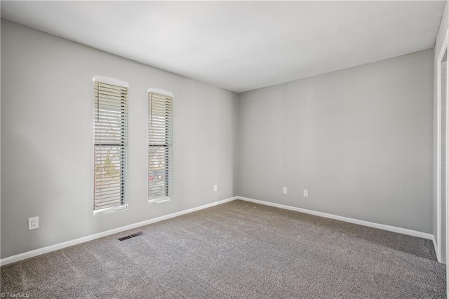 carpeted spare room with baseboards and visible vents