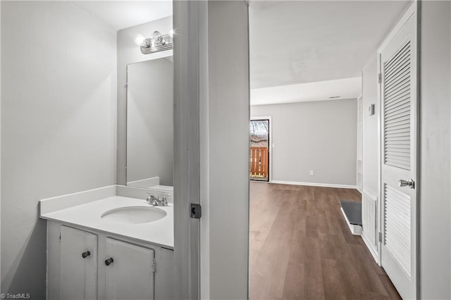 bathroom with wood finished floors, vanity, and baseboards