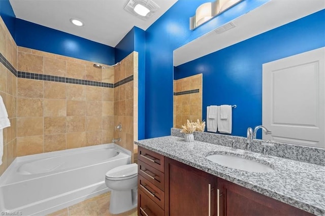 full bathroom with tile patterned flooring, tiled shower / bath combo, toilet, and vanity