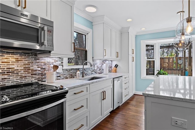 kitchen featuring ornamental molding, a sink, white cabinetry, stainless steel appliances, and decorative backsplash