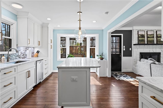 kitchen with dishwasher, ornamental molding, dark wood-style floors, and a sink