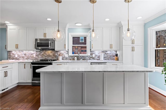 kitchen featuring dark wood-style flooring, a sink, ornamental molding, stainless steel appliances, and white cabinetry