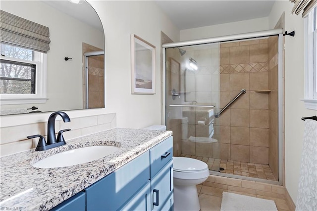 full bathroom featuring vanity, toilet, and a shower stall