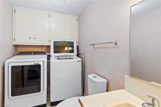 laundry room with laundry area, washing machine and dryer, and a sink