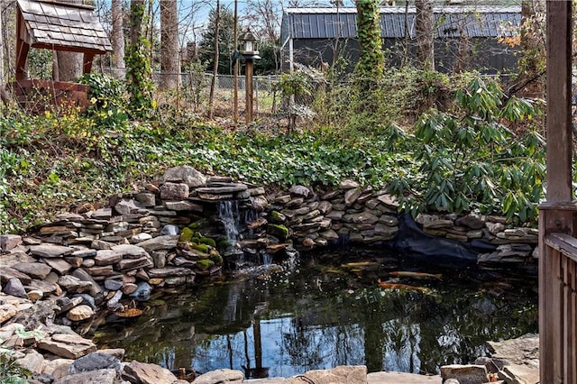 details featuring a small pond and fence