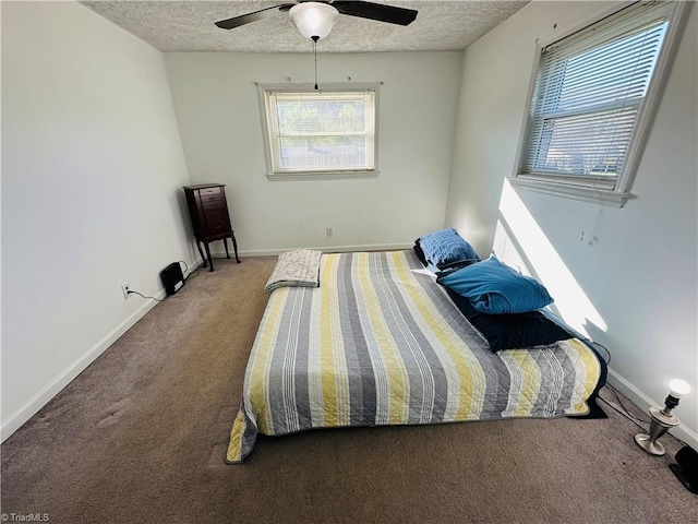 carpeted bedroom featuring a textured ceiling, ceiling fan, and baseboards