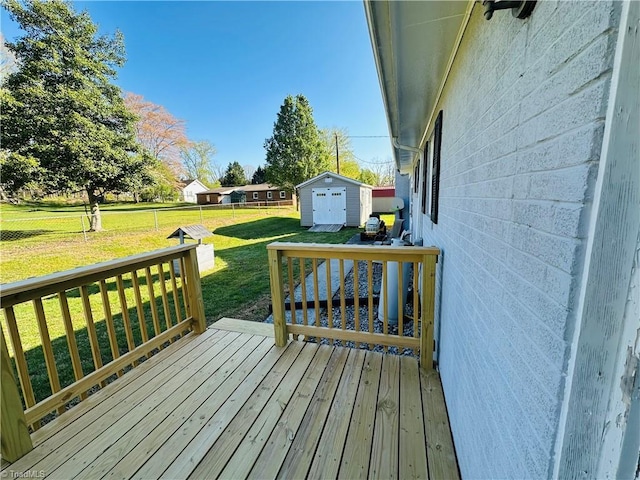 wooden deck with a storage shed, fence, an outdoor structure, and a lawn