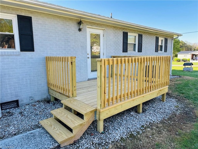 exterior space with crawl space, a deck, and brick siding