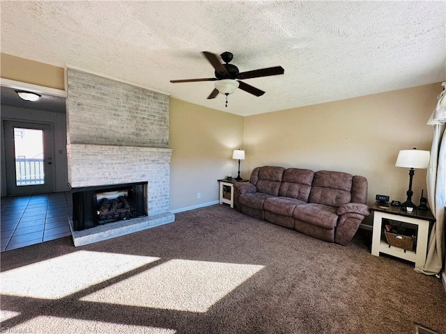 carpeted living room with a textured ceiling, a fireplace, a ceiling fan, and baseboards