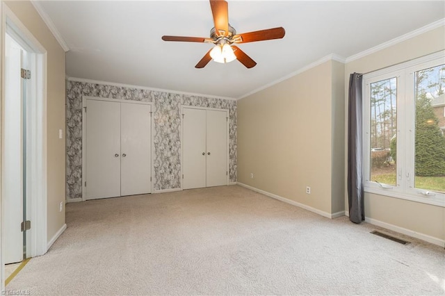 unfurnished bedroom with crown molding, baseboards, visible vents, and light carpet