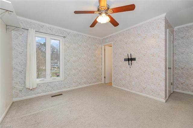 empty room featuring visible vents, crown molding, baseboards, ceiling fan, and carpet flooring