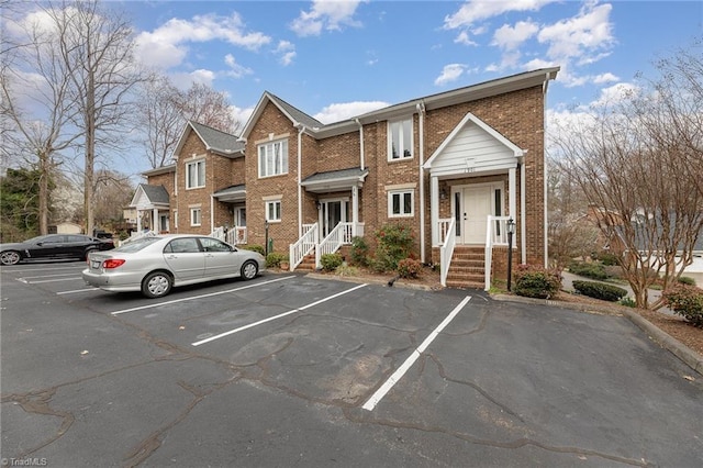 view of front of house featuring uncovered parking and brick siding