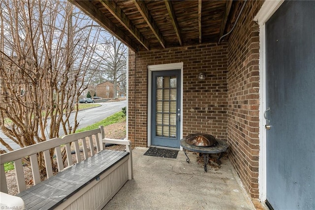 entrance to property with brick siding and a patio