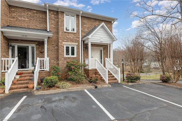 view of front of house featuring brick siding and uncovered parking