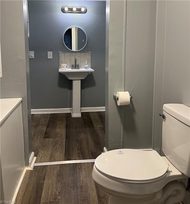 bathroom with toilet and hardwood / wood-style flooring