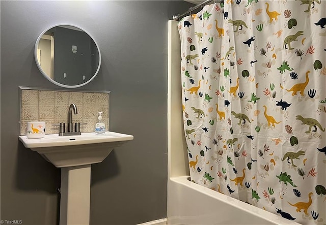 bathroom with decorative backsplash, shower / bath combo, and baseboards