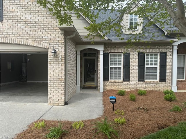 401 Pelican Ln, Clemmons, NC 27012 - doorway to property with a garage, brick siding, and concrete driveway