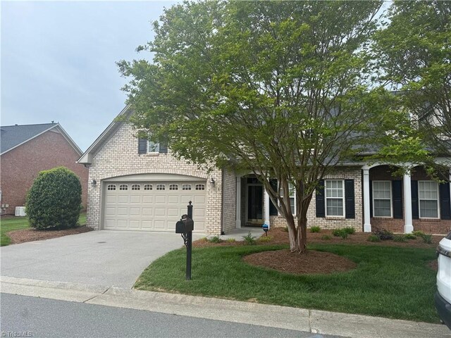 401 Pelican Ln, Clemmons, NC 27012 - obstructed view of property with concrete driveway, a front lawn, and brick siding