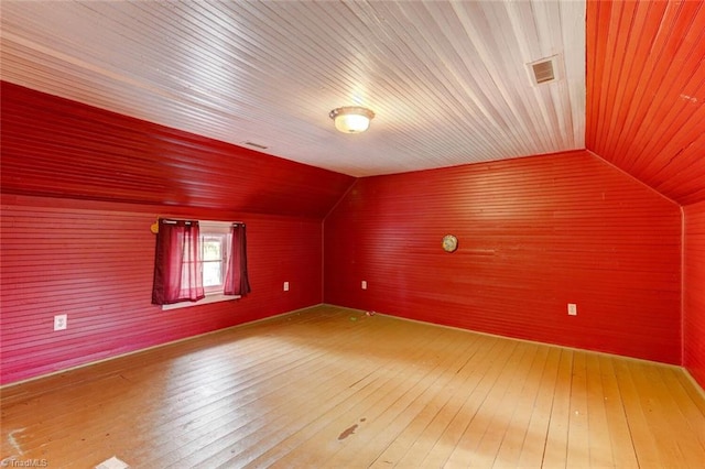 bonus room featuring vaulted ceiling and hardwood / wood-style flooring