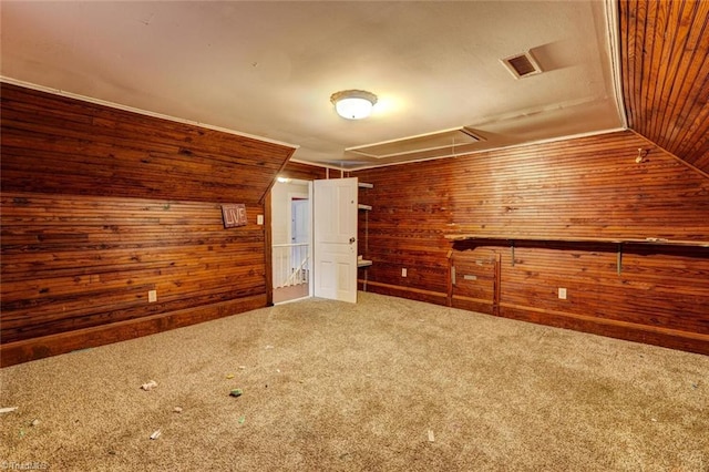 additional living space with lofted ceiling, wood walls, and carpet floors