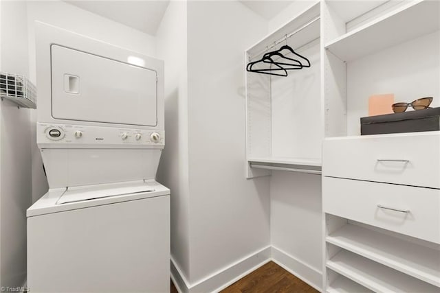 laundry area with dark hardwood / wood-style flooring and stacked washer and clothes dryer