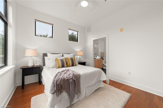 bedroom featuring hardwood / wood-style floors, ensuite bathroom, and ceiling fan