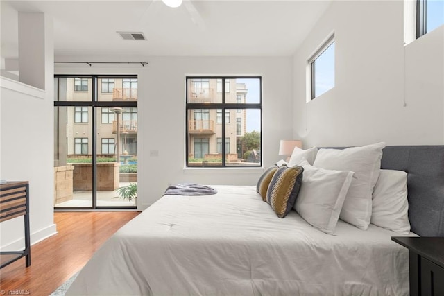 bedroom with access to outside, hardwood / wood-style flooring, and ceiling fan