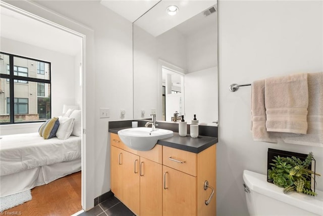 bathroom featuring wood-type flooring, toilet, and vanity