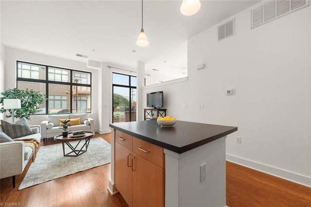 kitchen featuring pendant lighting, dark hardwood / wood-style floors, and a center island