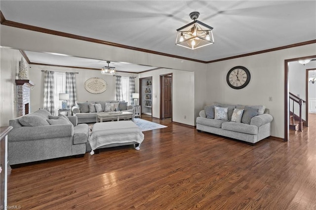 living room featuring an inviting chandelier, crown molding, and dark wood-type flooring