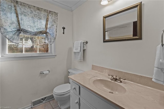 bathroom with tile patterned flooring, vanity, crown molding, and toilet