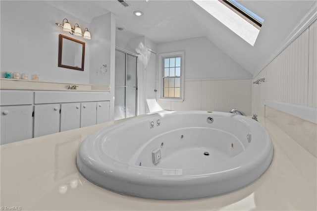 bathroom with vanity, vaulted ceiling with skylight, and independent shower and bath