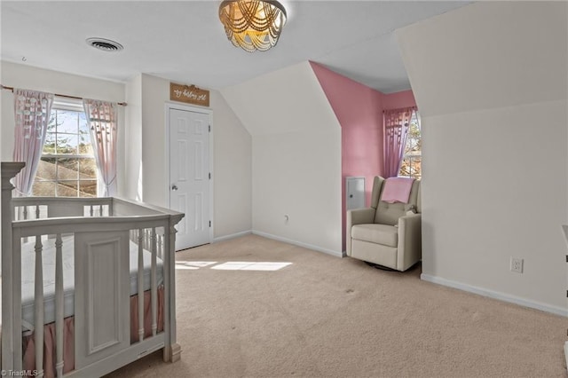 bedroom with vaulted ceiling, a nursery area, and light carpet