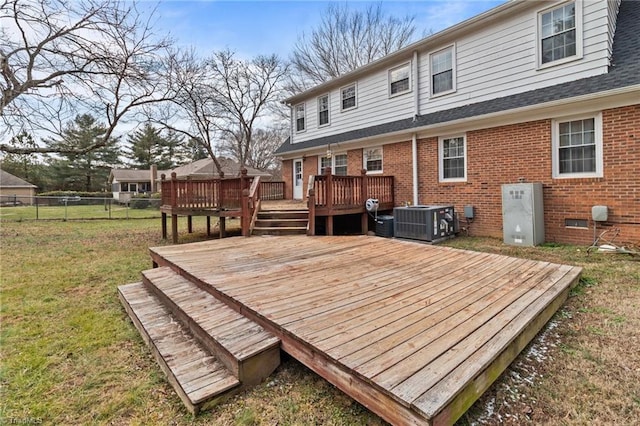 wooden deck featuring a lawn and central air condition unit