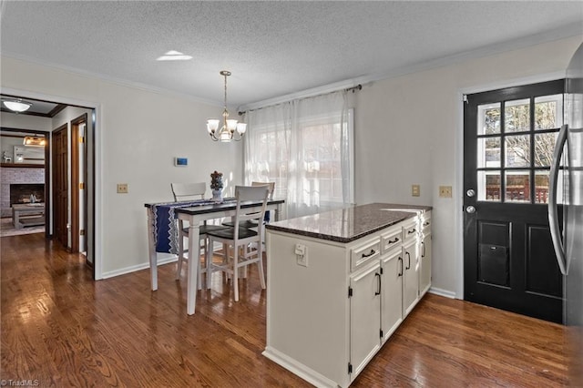 kitchen featuring crown molding, plenty of natural light, white cabinets, and a textured ceiling